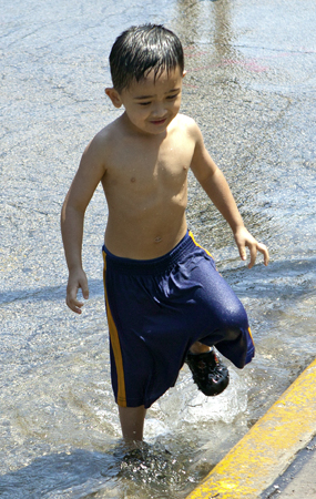 boy playing in water spray