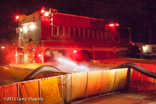 fire tanker dumping water into portable tank