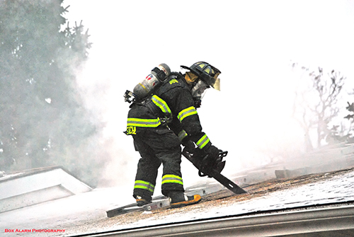 firefighter cutting into a roof