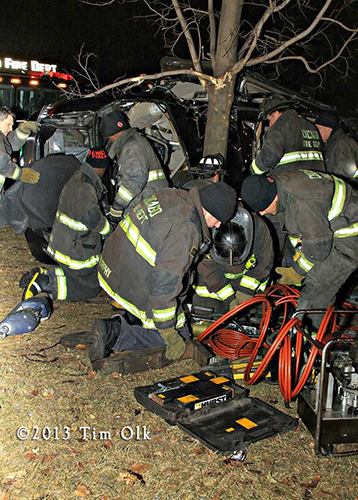 Chicago firefighters work to extricate a father and daughter from a one-car crash on Christmas eve