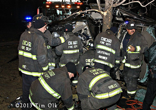 Chicago firefighters work to extricate a father and daughter from a one-car crash on Christmas eve