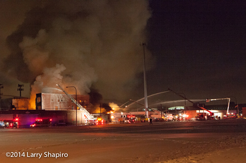 massive warehouse fire with wall of flames