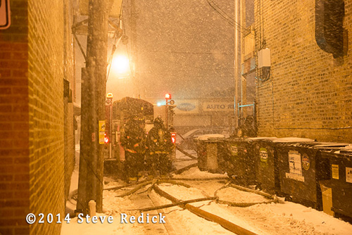 fire trucks at night fire scene with blowing snow