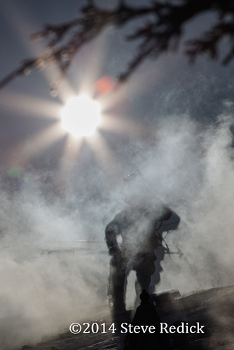 fireman silhouetted on roof with smoke