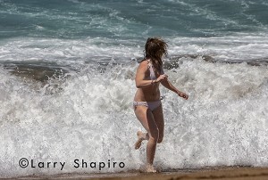 girl running from violent surf