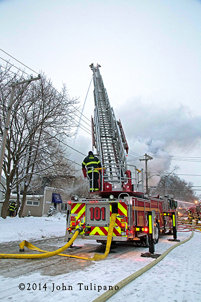 aerial ladder truck working at winter fire scene