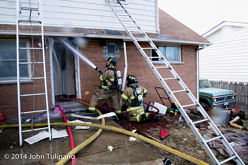 firemen with hose at house fire