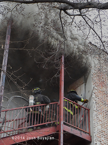 firemen make entry with heavy smoke overhead