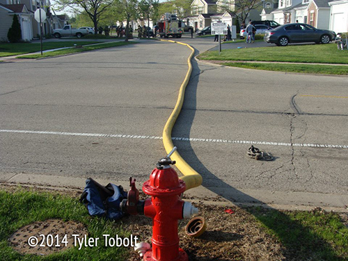 fire hydrant with hose at fire scene