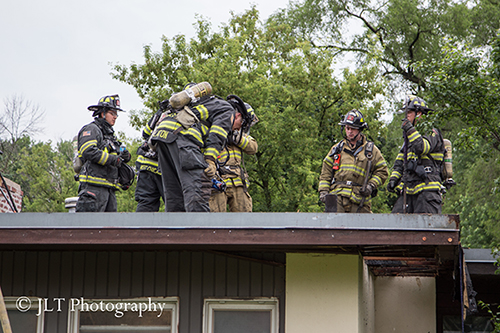 firemen on the roof of a house after fire