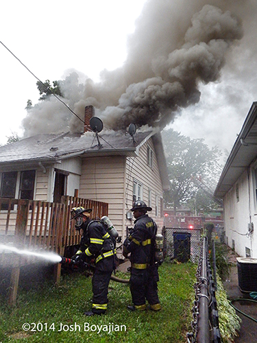 heavy smoke from roof of house fire