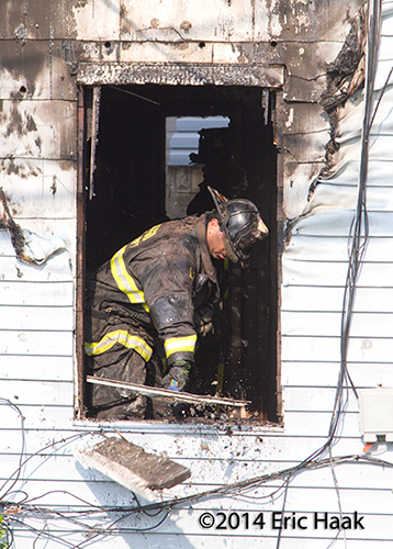 fireman doing overhaul after house fire