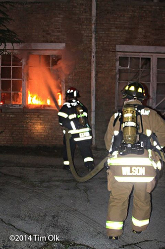 firemen with hose attack fire in a building