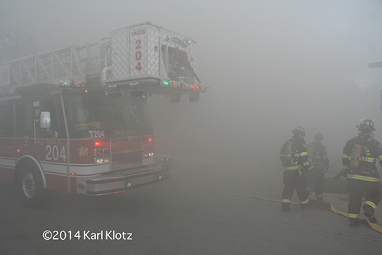 thick smoke engulfs firemen and fire truck