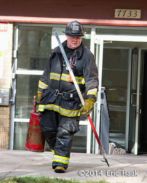 fireman carries tools after fire