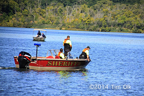 firemen in boat search lake for victim