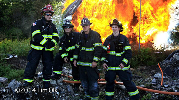 firemen posing in front of fire