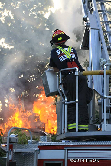 fireman operating ladder truck at fire scene
