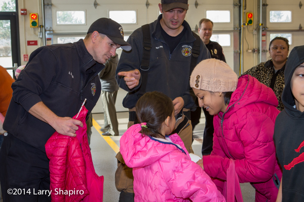 children receive free winter coats from firefighters