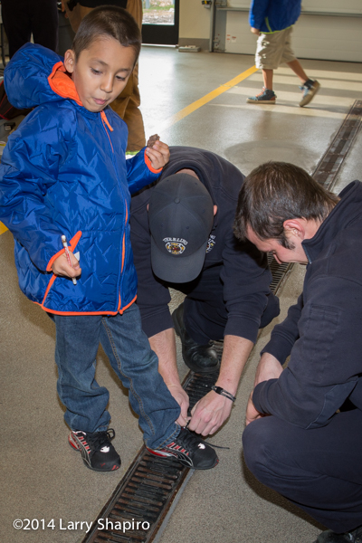 children receive free winter coats from firefighters