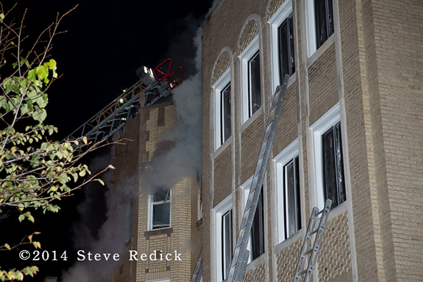 Chicago firefighters on aerial ladder with smoke