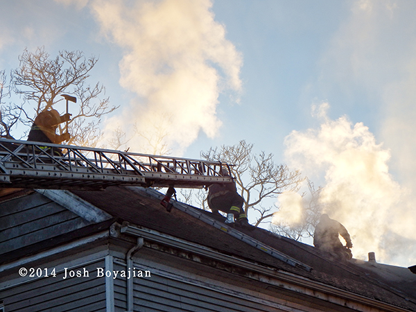 firemen on roof with aerial ladder