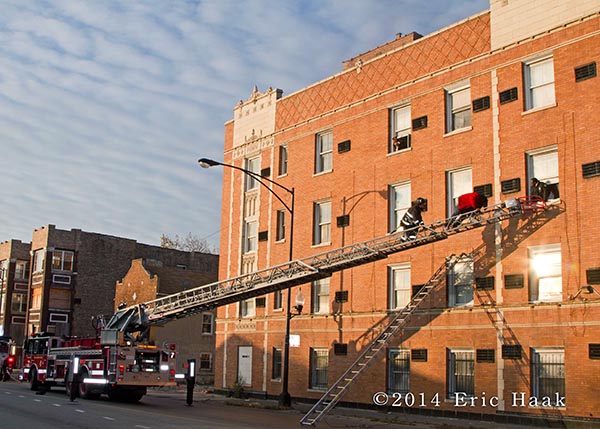 firemen rescue resident via ladder out the window of apartment building