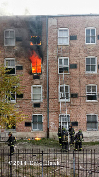 fire blows out the window of apartment building