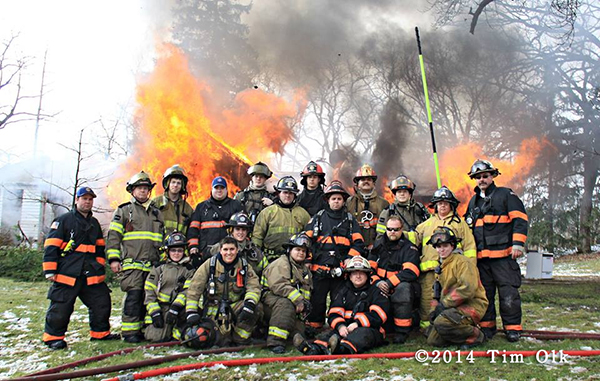 firemen posing by burning building