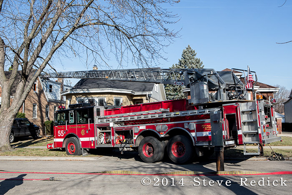firemen with aerial ladder to the roof of a house