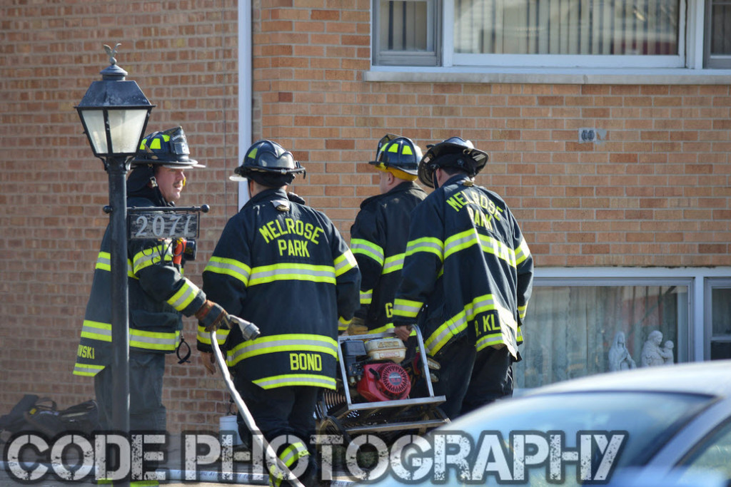 firemen carrying a smoke ejector fan