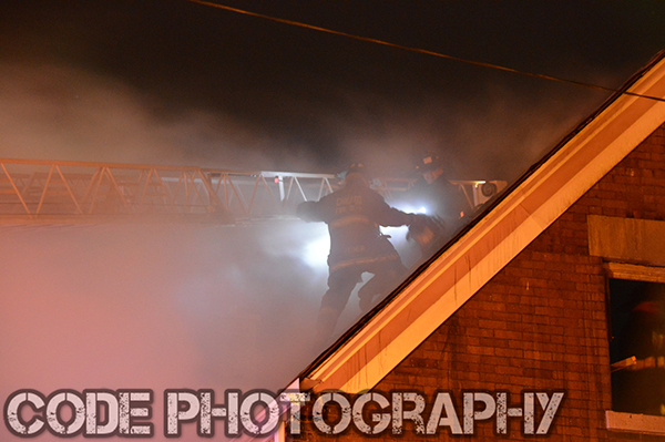fireman on roof at night with smoke