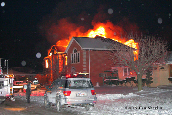 house fully engulfed in flames at night