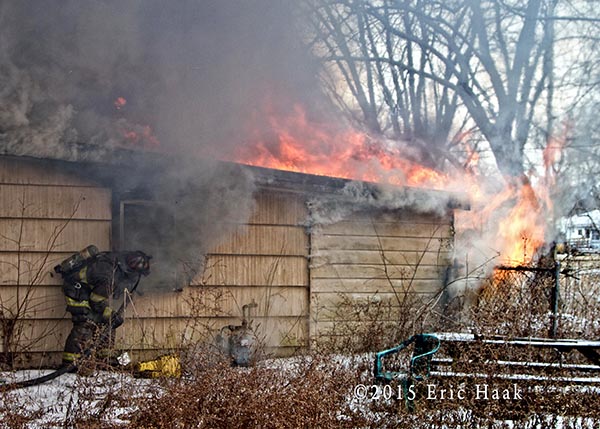 fireman stretching a line on a vacant house fire