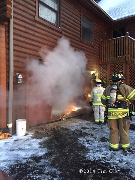 firemen cut residential garage door to attack a fire