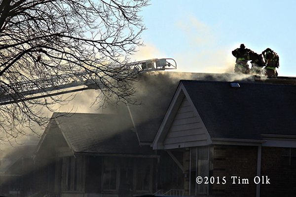 house fire with smoke and firefighters