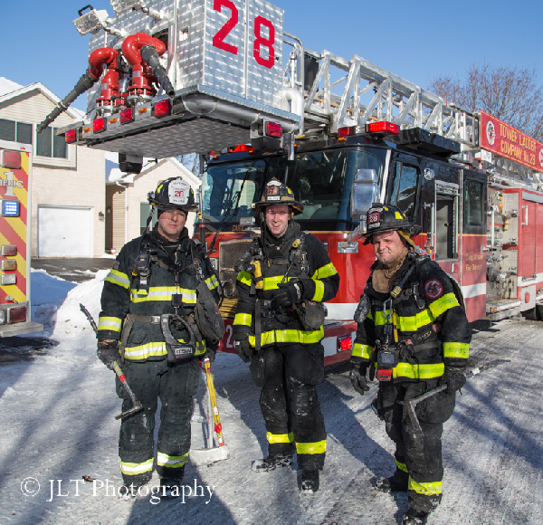 firemen pose with ladder truck