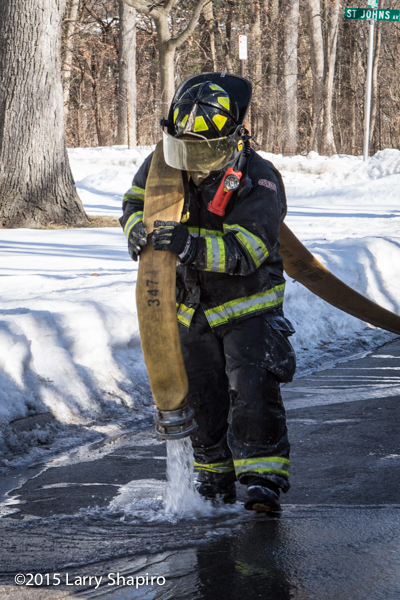 fireman drainign large diameter hose in the winter