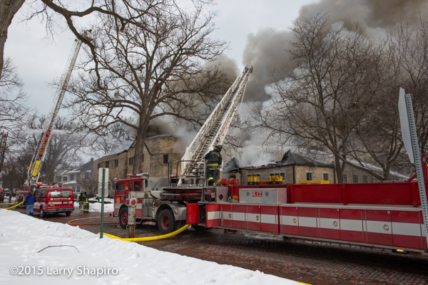Pierce aerial ladder truck as big flames burning through the roof