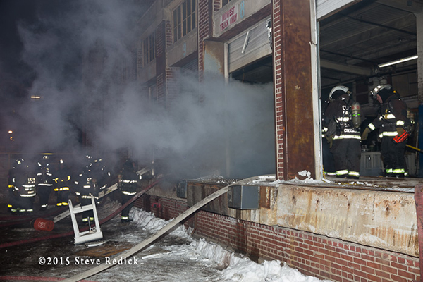 firemen work at a night winter fire scene in a commercial building