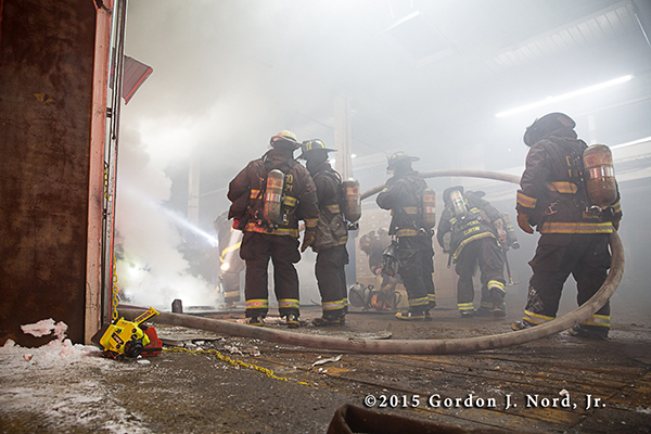 firemen battle smokey commercial fire at night