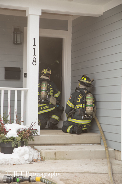 firemen making entry into a house