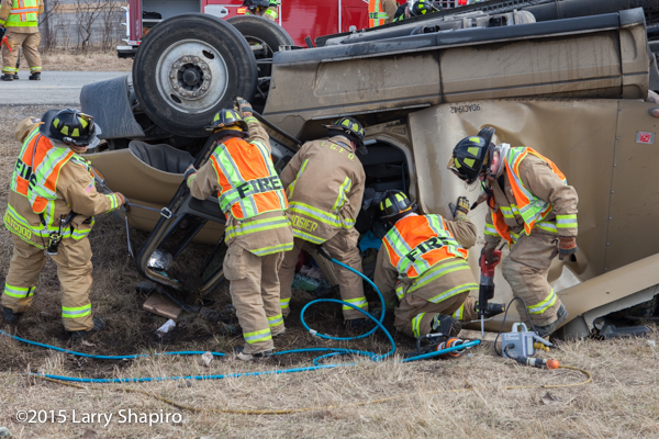 firemen rescue victim from rolled over semi tractor