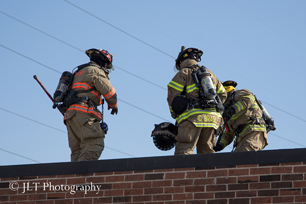 firemen on roof of commercial building