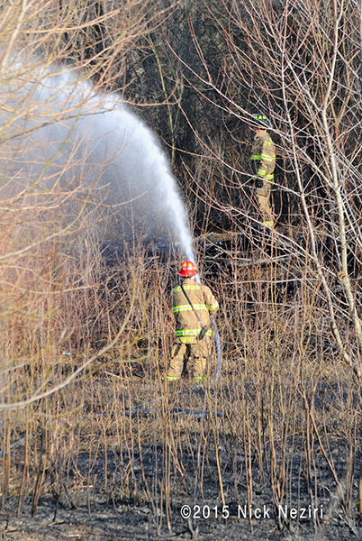 fireman with hose after brush fire