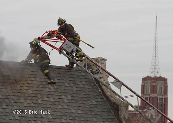 firemen venting peak roof at a fire