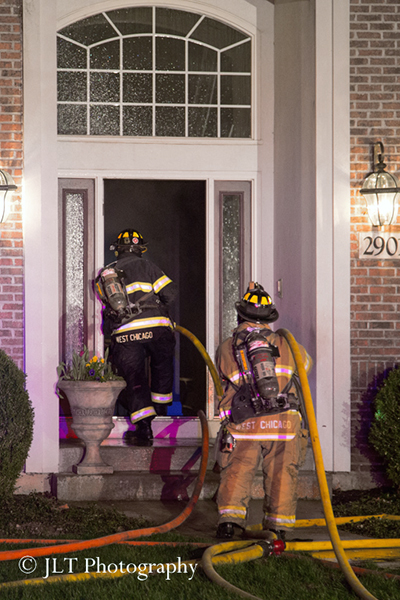 firemen with hose line at house fire