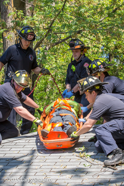 firemen remove an injured worker in a stokes basket