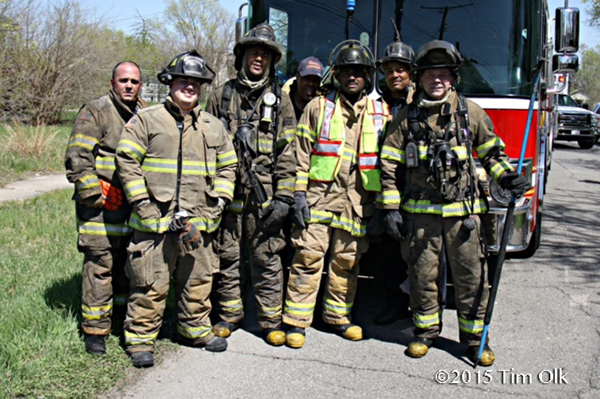 firemen pose after fighting a fire