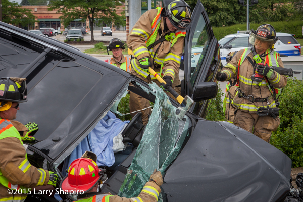 fireman uses ax to cut windshield